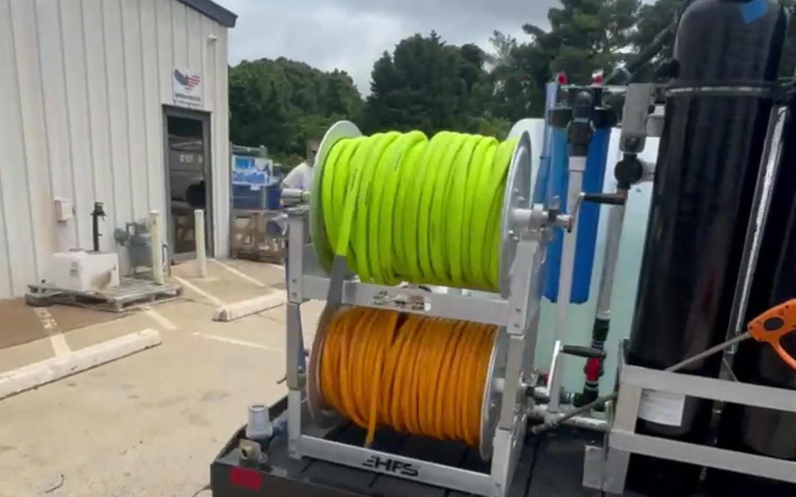 Hose reels and filtration hardware on a custom AmChem wash trailer